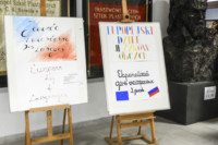 Dwie plansze w języku polskim i w obcych umieszone na sztalugach w dolnym holu korytarza. W tle dwa sztandary szkoły w gablotach. Kliknięcie w miniaturkę obrazka spowoduje wyświetlenie powiększonego zdjęcia.